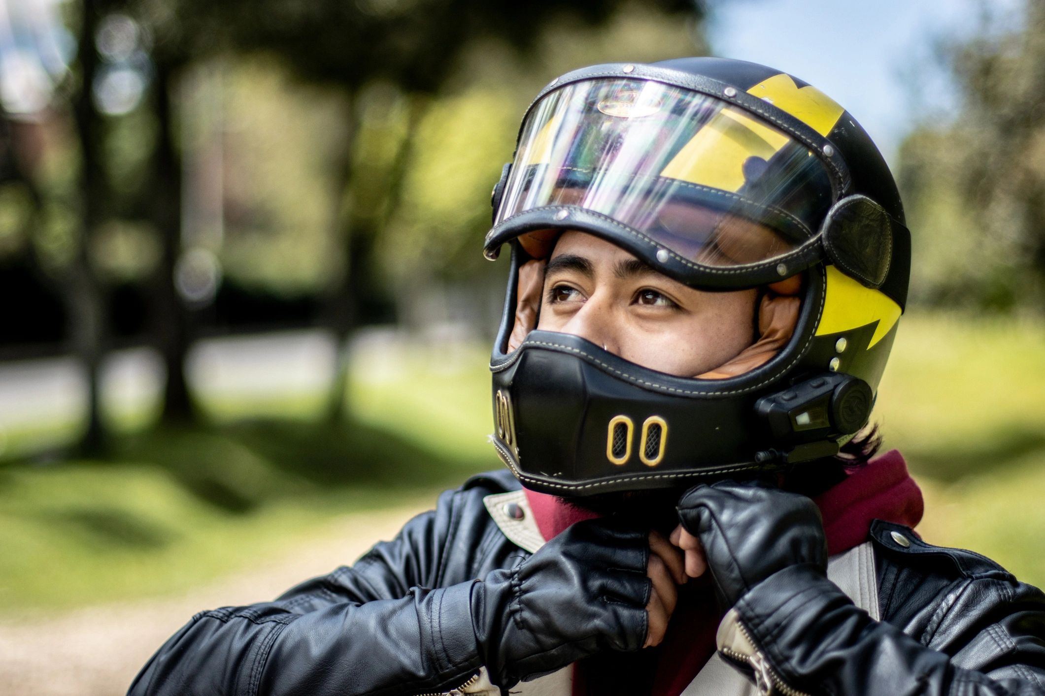 Person adjusting a motorcycle helmet strap