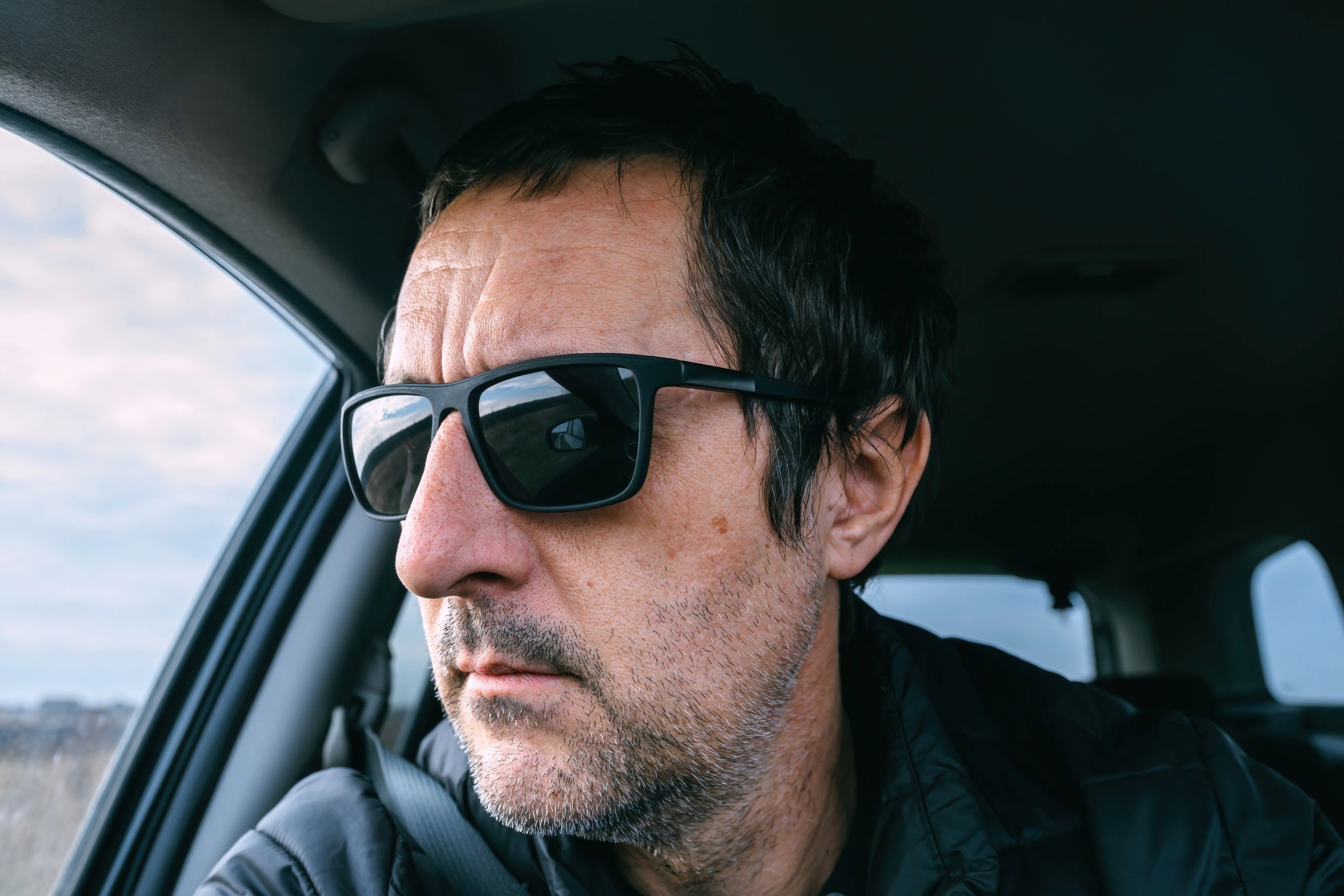 Man wearing sunglasses while driving